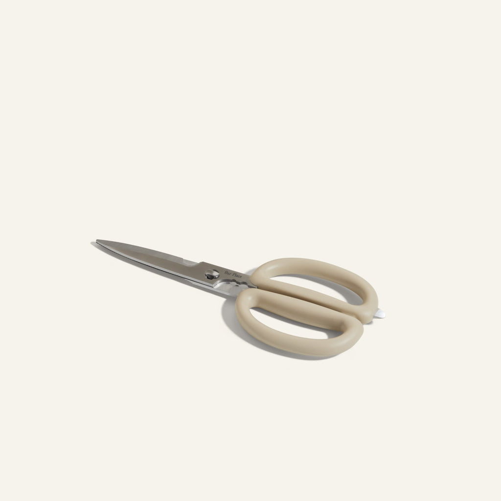 Shear Genius stainless steel kitchen shears with beige handles, offering a multifunctional design, displayed on a plain light background.